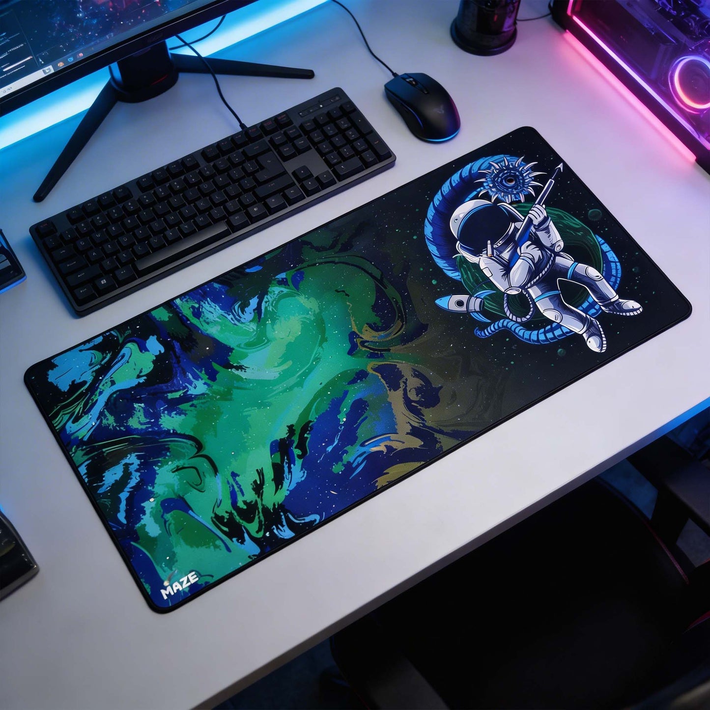 Desk setup with a large mouse pad featuring an astronaut design, keyboard, and mouse.